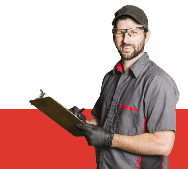 A close-up of an auto mechanic wearing a gray polo shirt, a gray cup, and gloves wringing on a clipboard.